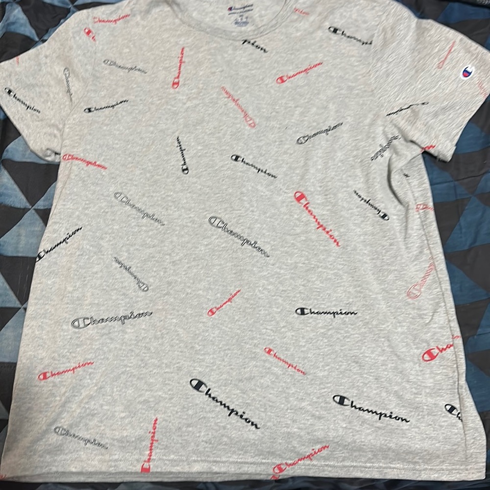 a grey/silver shirt with the word campion written in black,blue and red